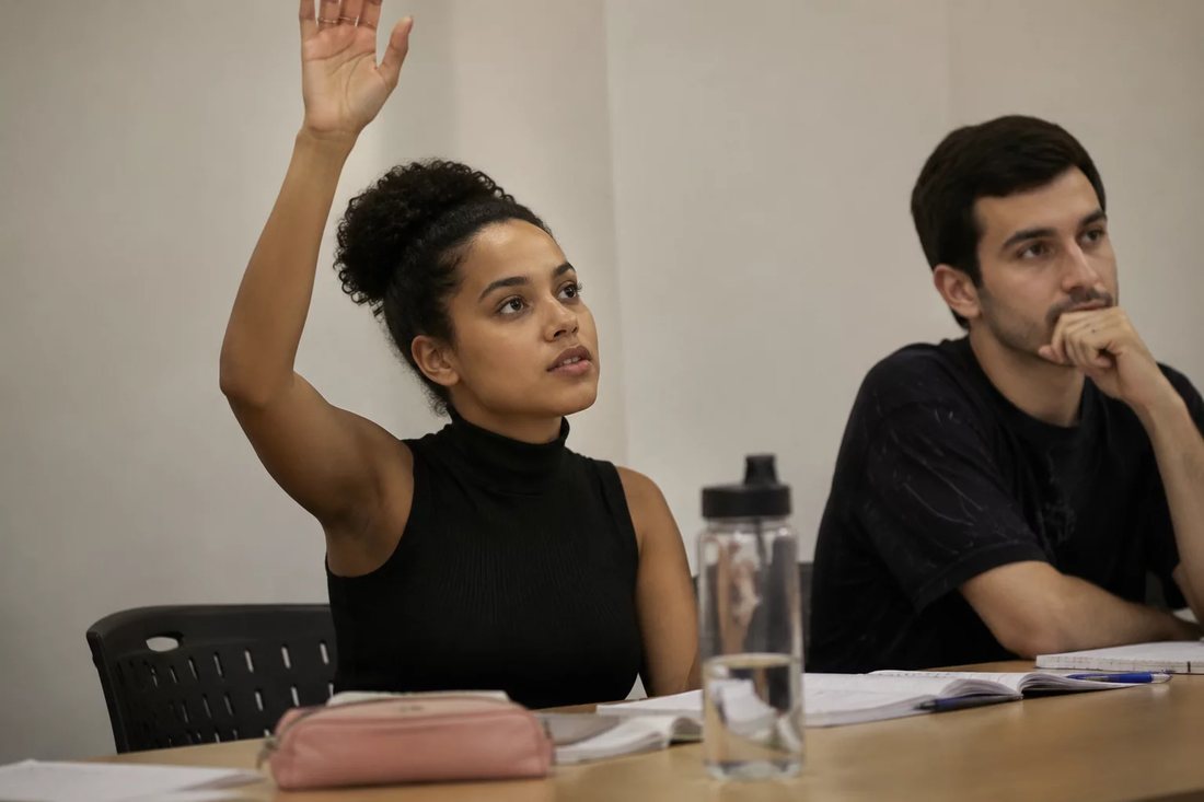 Facilitador em pé apontando para um argumento escrito no quadro durante a sessão